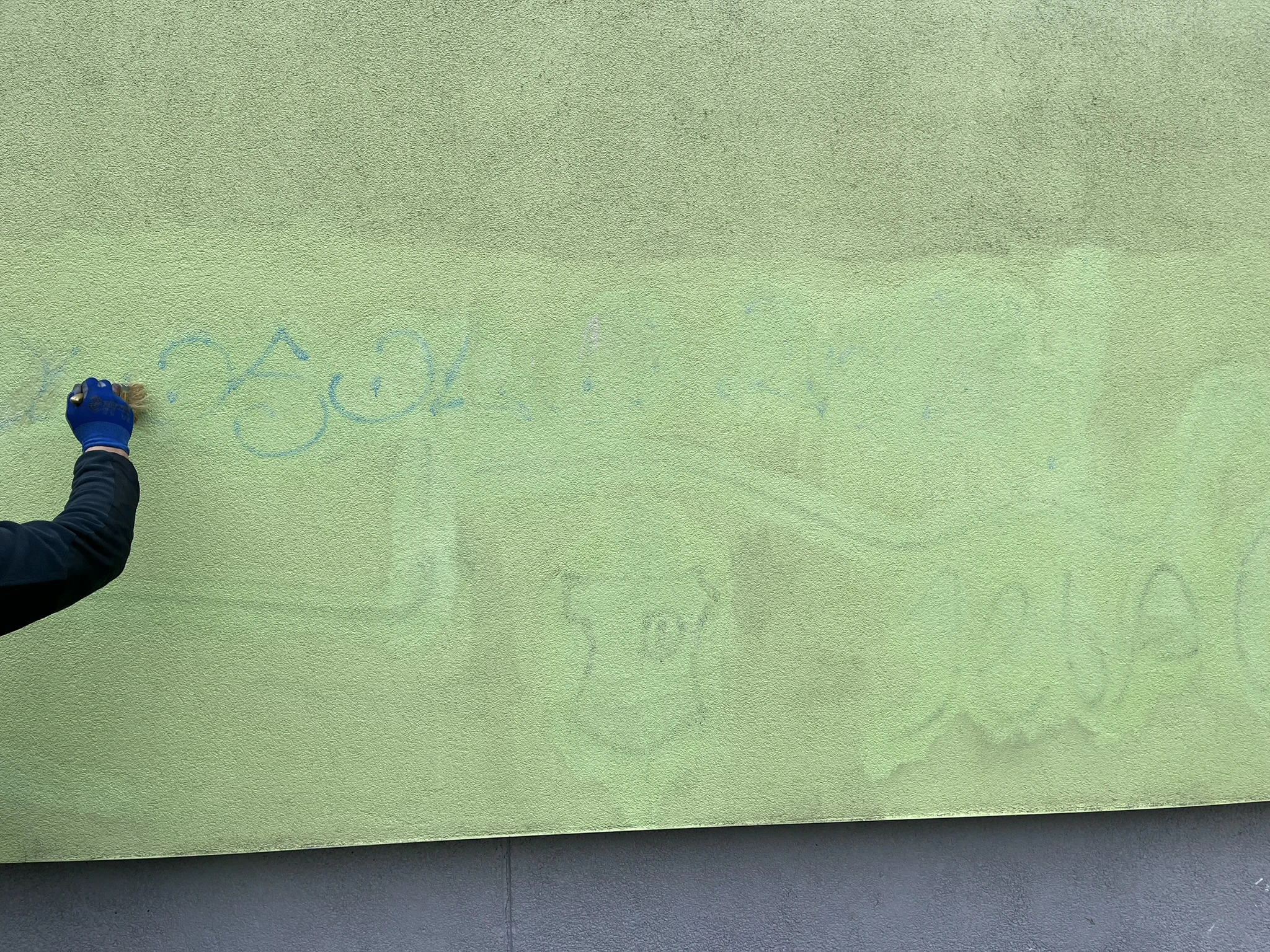 Usuwanie graffiti ze ściany elewacji szczotką